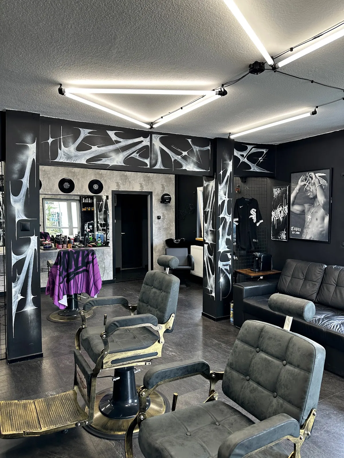 Wnętrze Barberground w Suchym Lesie: vintage fotele barberskie, graffiti na ścianie i sofa do czekania